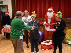 Mencap members receive presents at Christmas party