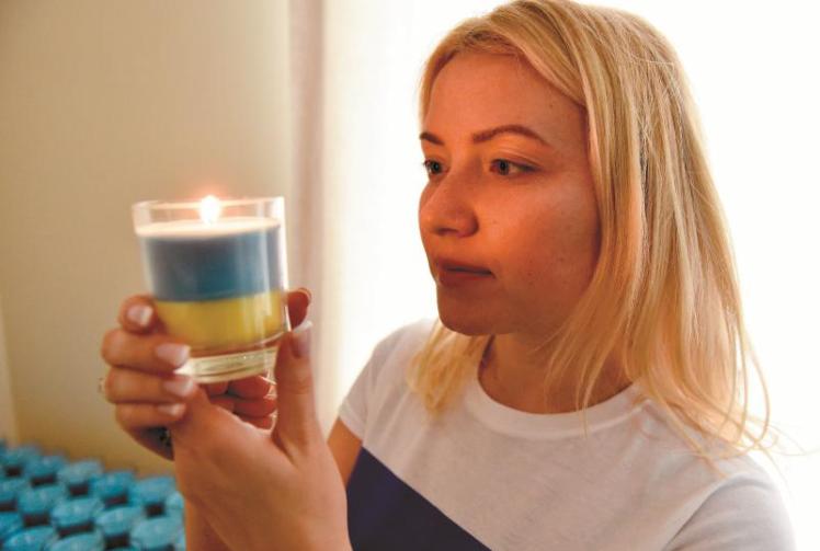 Ukrainian woman making candles to support stranded citizens 